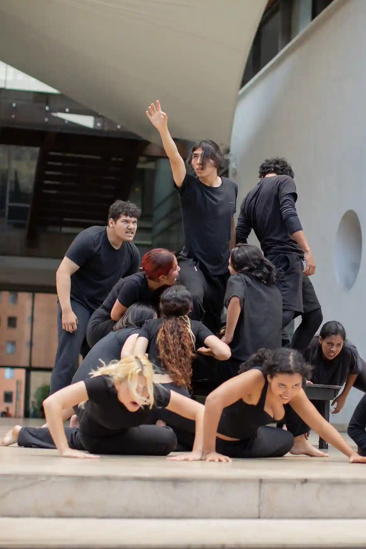 Un grupo de personas vestidas de negro, realizando una muestra artística. 