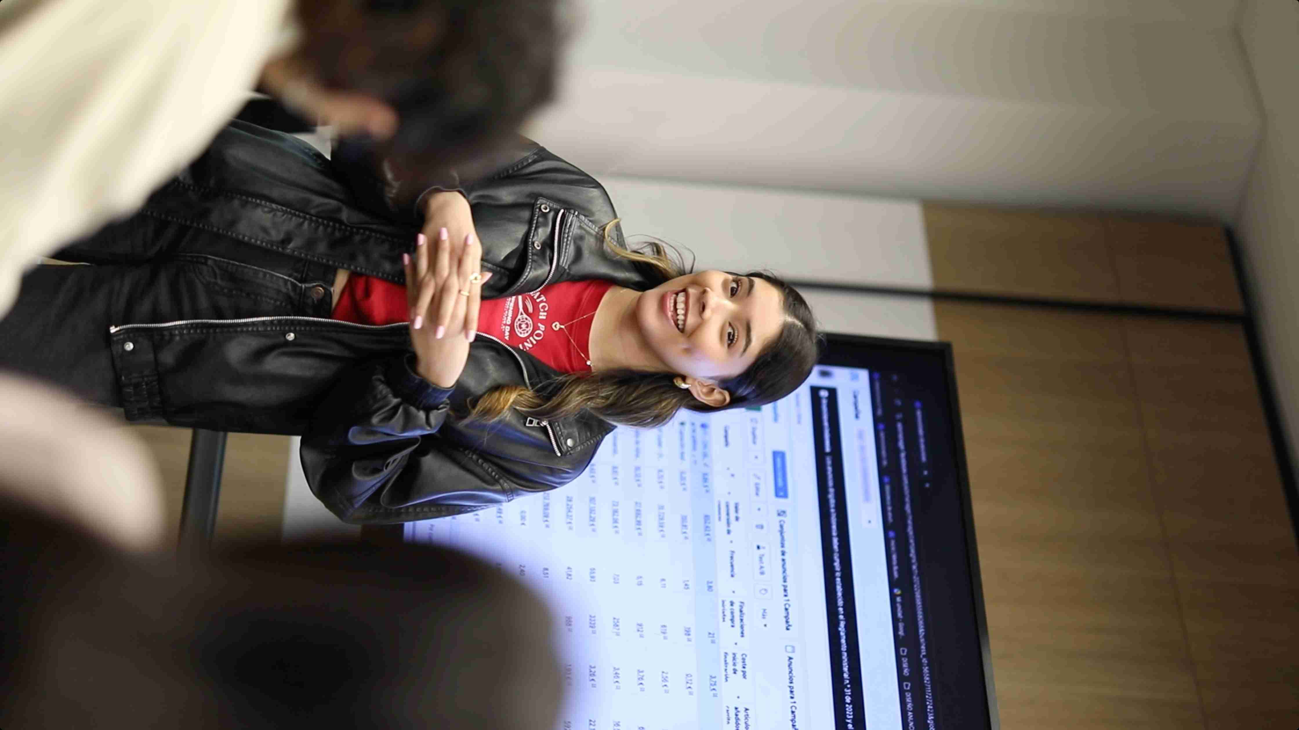 Mujer sonriendo en presentación a un grupo de personas 