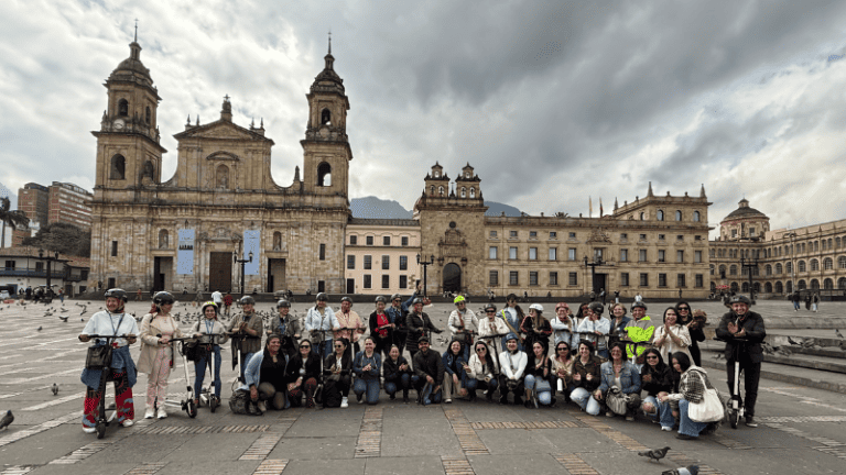Un grupo de personas posando para una foto frente a la plaza de Simón Bolívar.