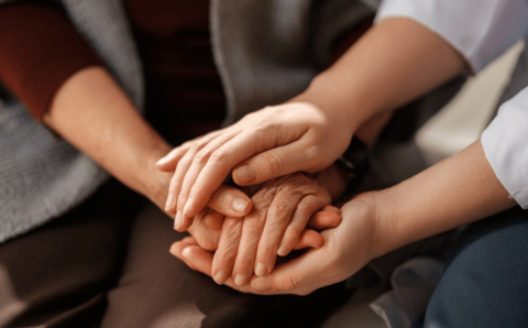 Manos de dos generaciones entrelazadas, en un gesto de acompañamiento y apoyo emocional