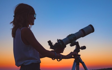 Persona viendo un eclipse desde un telescopio
