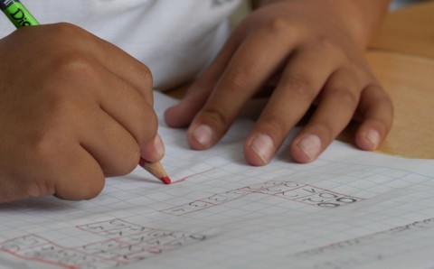 Niño escribiendo en su cuaderno durante una clase en el colegio