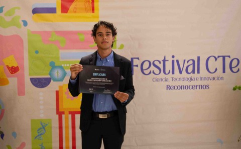 Estudiante con el diploma de la categoría Investigación e investigación-creación del Concurso de Excelencia Investigativa Estudiantil.