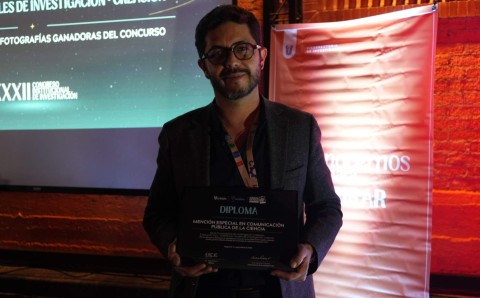 Juan Sebastián López con el diploma de la Mención Especial en Comunicación Pública de la Ciencia de Ciencia en Foco por la obra Nichos vacíos.