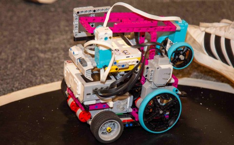 Robot de sumo armado con piezas de construcción de colores sobre la pista circular de competencia.