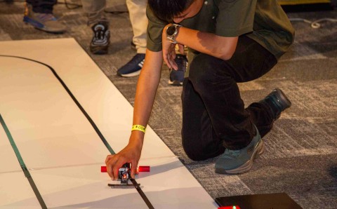 Competidor ubica su robot velocista en la línea de salida de la pista del Torneo RHA Robotics 2026.